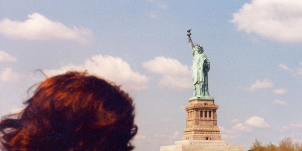 Immigrant looking upon the Statue of Liberty / iStock